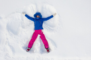 Fototapeta na wymiar Happy young woman having fun and making snow angel, top view. Selective focus.