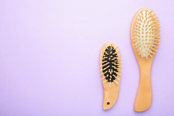 Obraz premium Set of comb and hairbrush on purple background with copy space