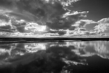 Black and white image of the reflections on Chalkwell beach, near Southend-on-Sea, Essex, England