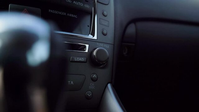 Car interior, man changes the volume of the music