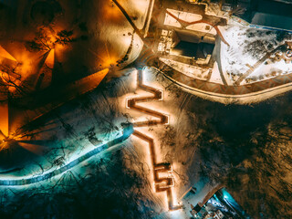 Aerial view from a drone to a staircase illuminated by diode lights on a landscape alley in the...