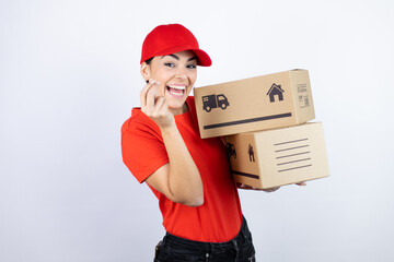 Young beautiful woman wearing courier uniform holding delivery packages doing money gesture with...