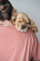 Young woman hugs her dog. The dog lies on the shoulder at a young woman. High quality photo