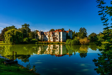 Fototapeta na wymiar Güttmannsdorf Castle, a neo-Gothic castle on a small lake in Dobrocin, Poland.