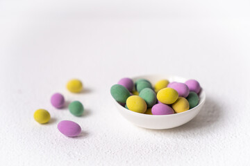 Easter concept. Mini eggs in little plate on white background. Color eggs pattern, easter background.