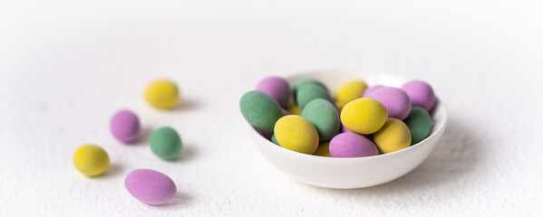 Easter concept. Mini eggs in little plate on white background. Color eggs pattern, easter background.
