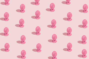 Easter pattern made of pink glittering eggs and bunny on pastel background. Festive concept