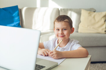 Schoolboy is studying online. The boy is engaged. Quarantine.