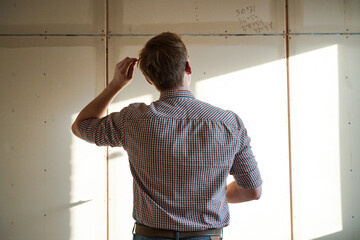 Pensive worker looking at the wall