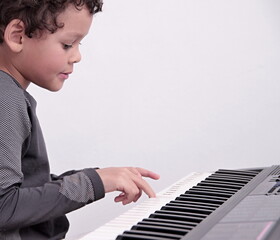 Fototapeta na wymiar boy playing the piano keyboard on white background stock photo