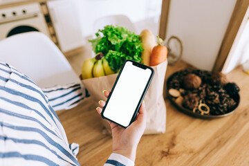 Woman hold the smartphone with white screen, mock up. Online food market concept.