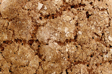 Top crust of homemade fresh bread loaf. Top view close-up texture background.