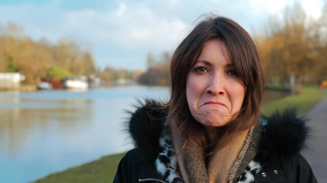 Portrait of attractive adult woman pulling silly faces and smiling outdoors. Happy active lifestyle.