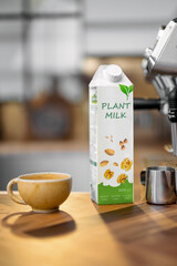 Packaging of vegetable milk near a cup of coffee and coffee machine on wooden table top on the kitchen. Organic nut dairy, alternative drink.
