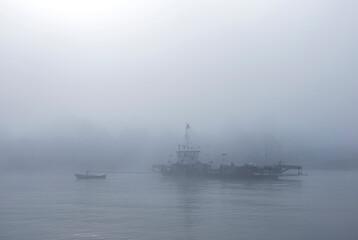 ferry in the mist on river lek near culemborg and utrecht