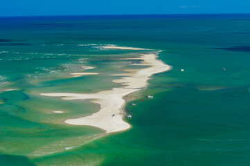 Obraz premium Sandbank in the bluish green sea, with boats and people, on the beach of Catuama, near Recife, Pernambuco State, Brazil on November 15, 2012.