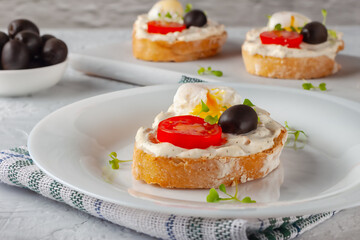 Bruschetta with tomato, olives and poached quail egg