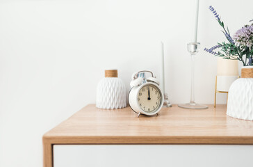 White alarm clock on wooden table with copy space.