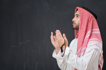 Arab man in traditional clothes praying to God or making dua
