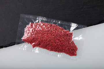 Crushed and dried raspberry flakes in vacuum sealed plastic bag