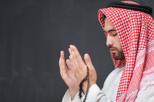 Arab man in traditional clothes praying to God or making dua
