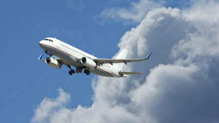 Fototapeta na wymiar Zoom photo of passenger airplane flying above clouds in deep blue sky