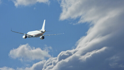 Fototapeta na wymiar Zoom photo of Airbus A320 passenger airplane flying above clouds in deep blue sky