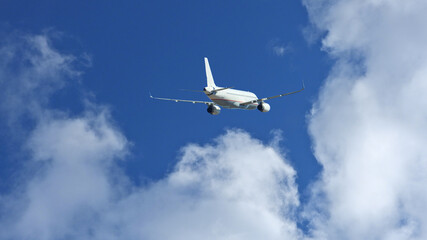 Fototapeta na wymiar Zoom photo of passenger airplane flying above clouds in deep blue sky