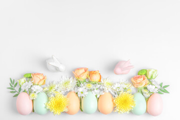 Creative layout composition of flowers and easter eggs on pastel background.