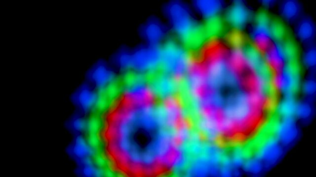 Abstract blurry, flashing light shapes bouncing on a black wall. Vivid, colourful disco light effects with different shapes, dots and forms are dancing on the wall