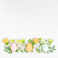 Creative layout composition of flowers and easter eggs on pastel background.