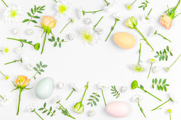 Creative layout composition of flowers and easter eggs on pastel background.