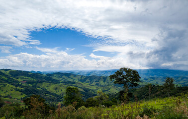 panorama of the beautiful rural landscape of Pico da Raposa. sunny afternoon with sun rays. wonderful spring landscape in the mountains. trees and vegetation in wide landscape. rural landscape with wh