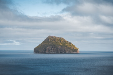 Fototapeta na wymiar Picturesque green cliffs on Litla Dimun island and atlantic ocean in Faroe islands.