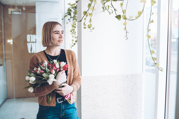 Girl standing at the window with a bouquet of tulips. Bouquet of tulips.