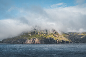 Picturesque green cliffs on Litla Dimun island and atlantic ocean in Faroe islands.