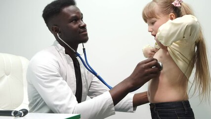 Little girl having a check up at pediatrician. The doctor is pulping and checking child's breathing, hearing and throat. - Powered by Adobe