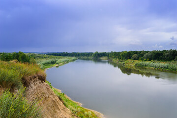Landscape of calm river and stormy sky