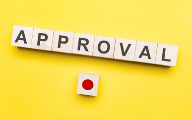 The word approval written on wood blocks with button. Concept of approving in business or finance.