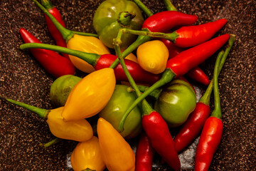 Porção de pimentas variadas. Pimentas verdes, vermelhas e amarelas dentro de uma vasilha.