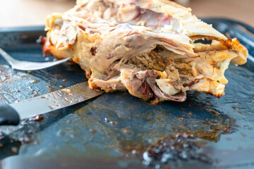 Leftover food. hicken carcass. Cutlery, knife.