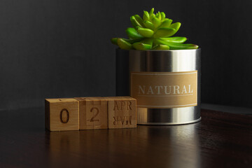 April 02. Image of the calendar April 02 wooden cubes  on a brown wooden table reflection and black background. with empty space for text