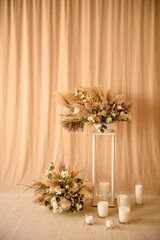 Decorations from dry beautiful flowers in a white vase on a beige fabric background