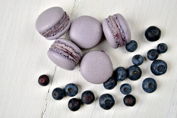Blueberry macarons on a white wooden table with blueberries close up 