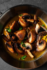 Closeup stewed mushrooms in butter in a hot pan