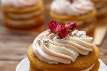 Sponge cake with cream, decorated with small flowers.