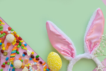 Easter composition with sweets and bunny ears space for text. Top view, flat lying.