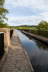Scottish  aquaduct over a river near Linlithgow with blue sky and hills in the distance