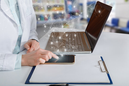 Doctor Works With Locations On The Network At The Table In The Office.