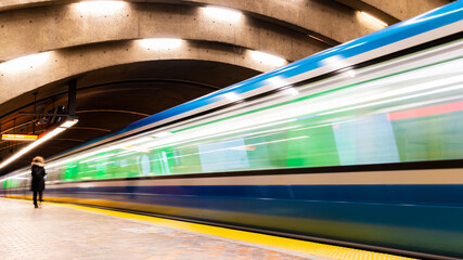 Long exposure photography of a subway train in motion in a station